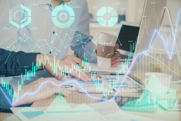 Multi exposure of chart with man typing on computer in office on background. Concept of hard work.