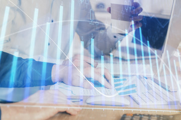 Multi exposure of chart with man typing on computer in office on background. Concept of hard work.