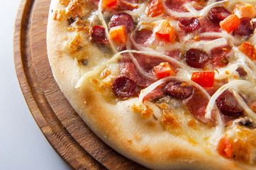 meat pizza lies on a wooden round board on a white background, close-up