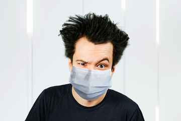 Unhappy, mad person wearing a protective face mask prevent virus infection or pollution