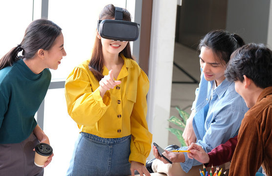 VR mobile phone application test, Asian woman with virtual reality headset in VR experience, Young asia business team developers meeting for reality simulator smartphone app test at creative office
