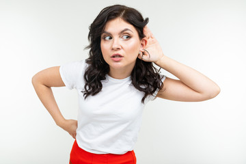brunette girl in a white t-shirt eavesdrops on a conversation on a white background