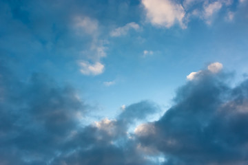 Blue sky with contrasting light and dark cumulus clouds. Sky pattern.	