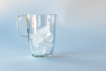 The glass cup is packed with natural ice. Not a big stream of water and fills it. Close-up. Copy space.