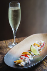 Lubina Ceviche with lime juice, shallots, a wedge of lime and fried garlic