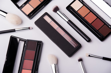 Cosmetic palette with brushes lies on a white background