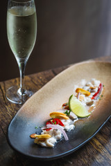 Lubina Ceviche with lime juice, shallots, a wedge of lime and fried garlic