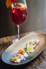 Lubina Ceviche with lime juice, shallots, a wedge of lime and fried garlic
