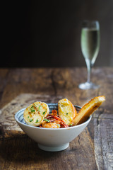 Prawns Al Ajillo with garlic, fried garlic, chilli oil and garlic bread in a bowl