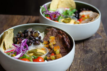 Protein Bowl of grilled Striploin, pilaf rice, beans, guacamole, homemade spiced cheese sauce, jalapenos & corn chips