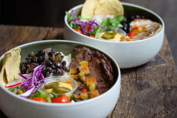 Protein Bowl of grilled Striploin, pilaf rice, beans, guacamole, homemade spiced cheese sauce, jalapenos & corn chips