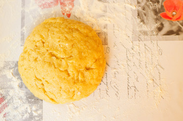 A ball of sweet pastry for shortcake lies on a table sprinkled with flour. Homemade baking. Selective focus.