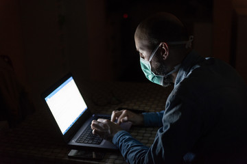 Man wearing mask and working from home in isolation from coronavirus