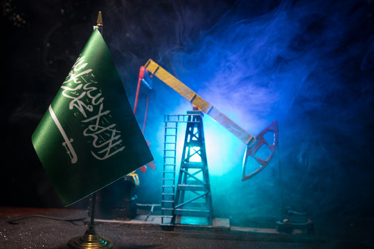 Business dialogue, oil agreement concept: National flags with Oil pump and oil refining factory at night with fog and backlight. Energy industrial concept.