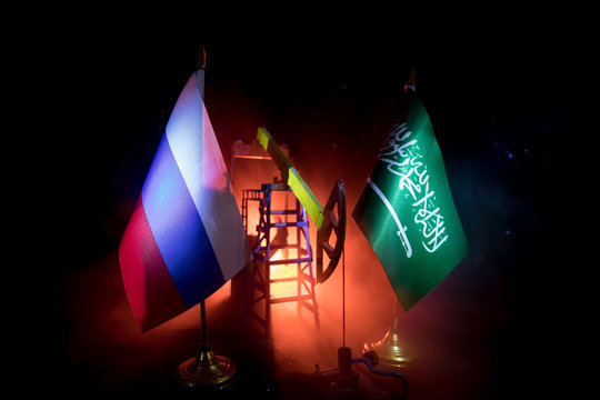Business dialogue, oil agreement concept: National flags with Oil pump and oil refining factory at night with fog and backlight. Energy industrial concept.
