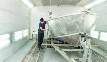 Aluminum boat painting procedure at service center ,The mechanic is using a metal grinder. , Surface preparation, boat body, for spray painting ship