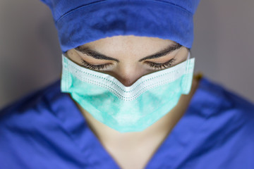 Almost frontal view of female doctor with mask and cap to visit patient with coronavirus.