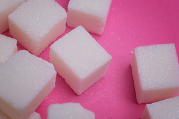 Sugar cubes on a bright pink background. Macro photo.