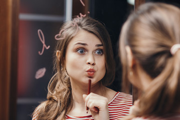 beautiful funny girl grimacing in front of a mirror with inscription affirmation I love you in the...