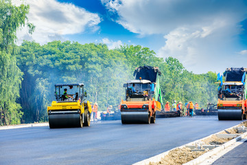Fototapeta na wymiar Construction site is laying new asphalt road pavement,road construction workers and road construction machinery scene.highway construction site landscape.