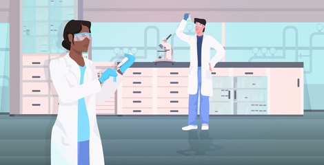 scientists couple holding test tubes working in medical lab mix race man woman researchers in white coats making chemical experiment modern laboratory interior horizontal vector illustration