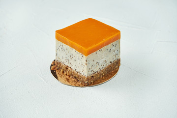 Appetizing pudding with cream and sponge cake with mango and chia flavor on a white texture background. Delicious pastries