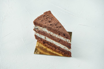 A slice of delicious strachatella chocolate cake with icing and sponge cakes. Close up. Delicious pastries