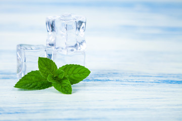 Ice and mint on a wooden table.