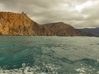 Fototapeta na wymiar sea, cliffs of black mountains and large thunderclouds
