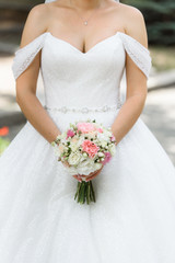 Bride holds a wedding bouquet in her hands