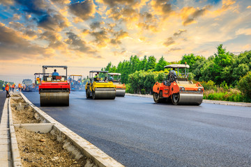 Construction site is laying new asphalt road pavement,road construction workers and road...