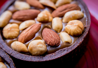 Chocolate cookies with almond nuts on a red plate. Restaurant.
