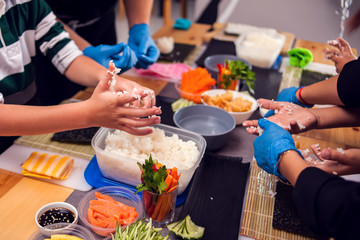 Children making sushi at the master class. Children, education and entertainment.
