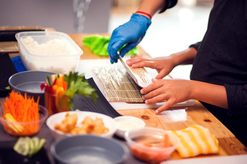Children making sushi at the master class. Children, education and entertainment.