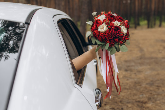 Wedding bouquet of flowers in hand exhibited from a car window