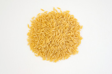 Italian pasta orzo on a white plate top view. Close-up of hard pasta in the shape of small rice. Pasta For risotto and salads.