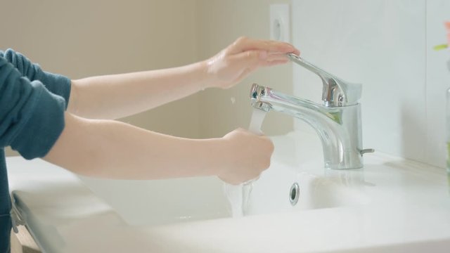 Lavage de mains. Petit gar&ccedil;on se lavant les mains avec pr&eacute;caution. Geste barri&egrave;re contre le coronavirus.
