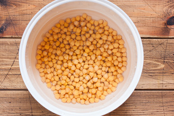 Raw chickpeas in a pan, drenched in water, before cooking, top view