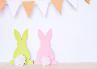 Easter background with paper rabbits and garland flags