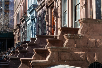 A Row of Old Colorful Brownstone Townhouses with Staircases on the Upper West Side of New York City	