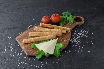 cheese sticks from puff pastry on a wooden cutting board