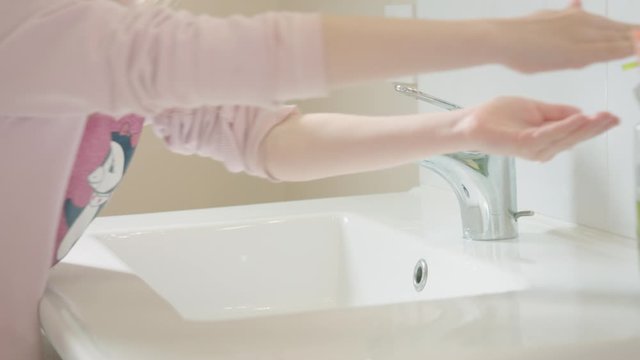 Lavage de mains. Petite fille se lavant les mains avec pr&eacute;caution. Geste barri&egrave;re contre le coronavirus.