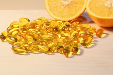 Yellow capsules with oil for medicine and ingestion or natural vitamins from oranges