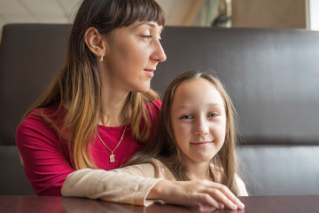 Portrait of mom with daughter in a cafe. Photographed close-up.