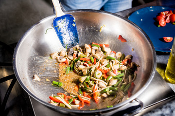 Chef cooking pasta with vegetables in pan. Italian style cuisine. Restaurant.