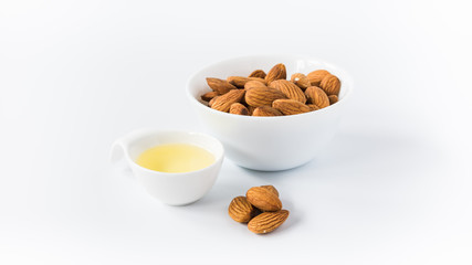 almond oil with nuts on a white background