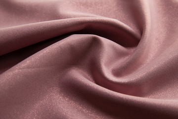 Beautiful fabric of one color is folded on a table in daylight