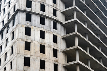 Concrete gray high-rise building close -up partially without external walls. Background