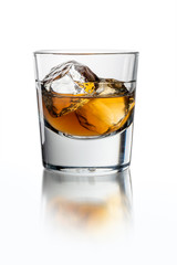 Glass with whiskey on the white background with ice