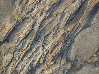 texture of dark rock washed by waves in the morning